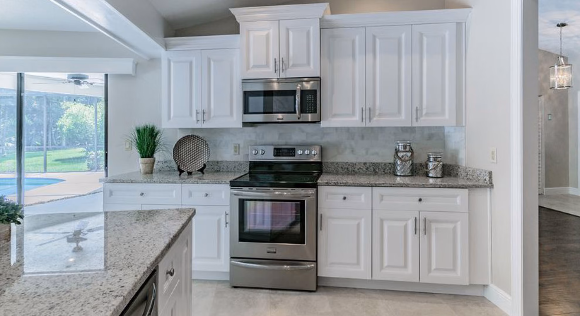 Kitchen: white raised-panel with range and pool view