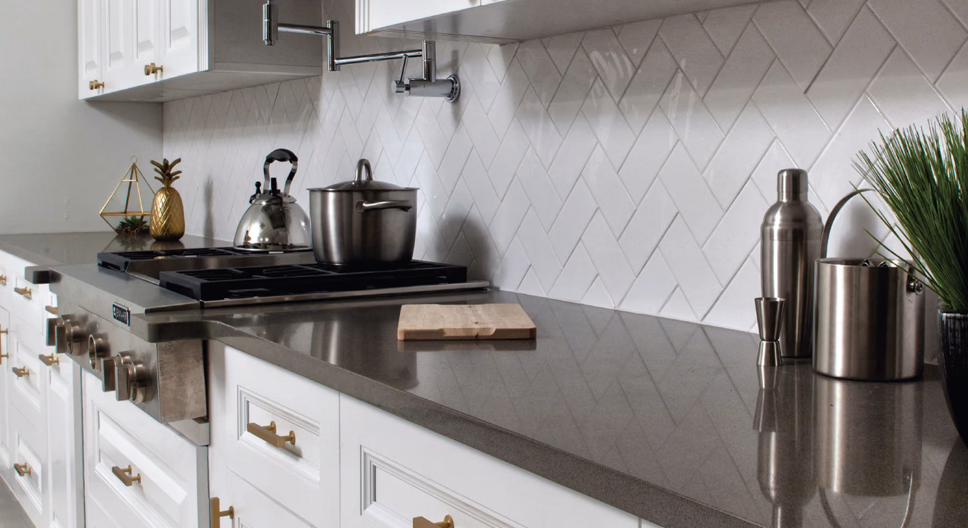 Kitchen close-up: white cabinets, herringbone backsplash, cooktop