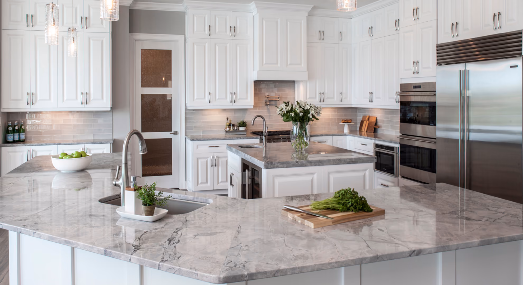 Kitchen: white island with marble top and produce
