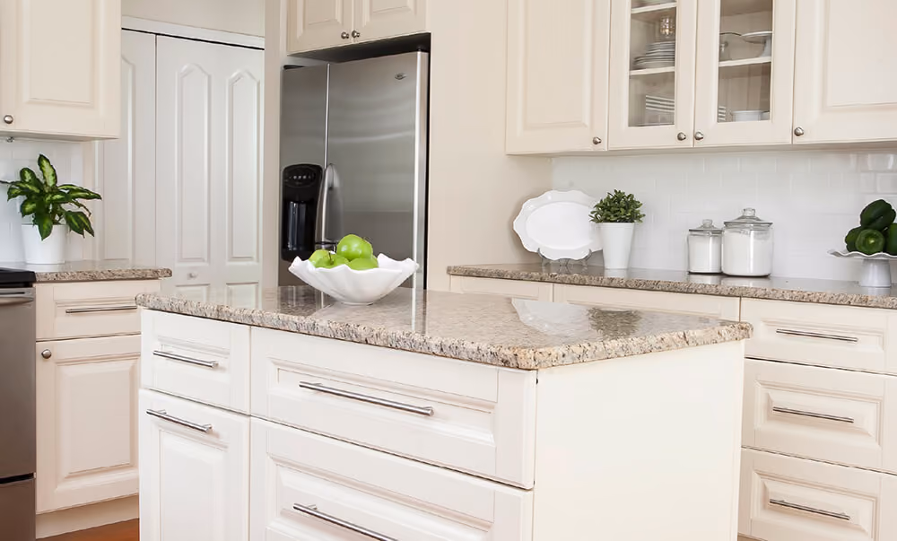 Kitchen: cream raised-panel island with granite