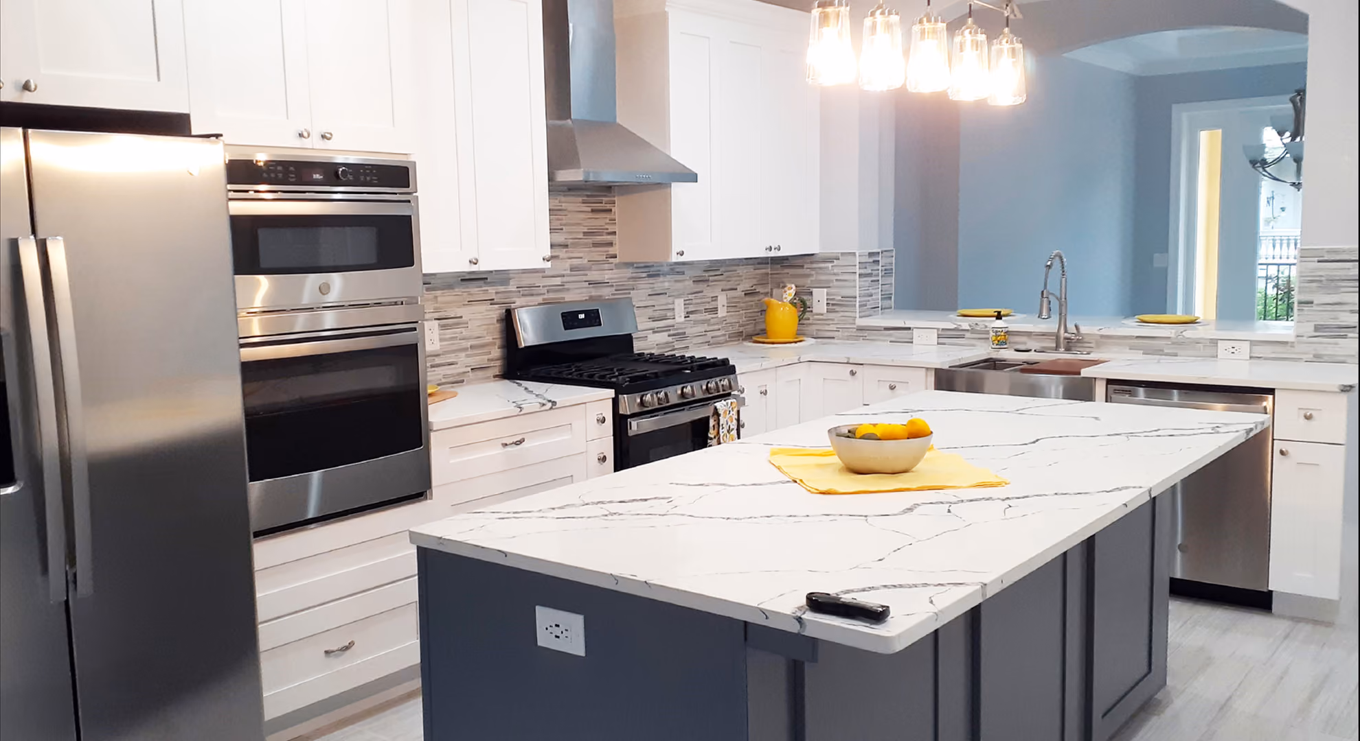 Kitchen: white with navy island, stainless double ovens