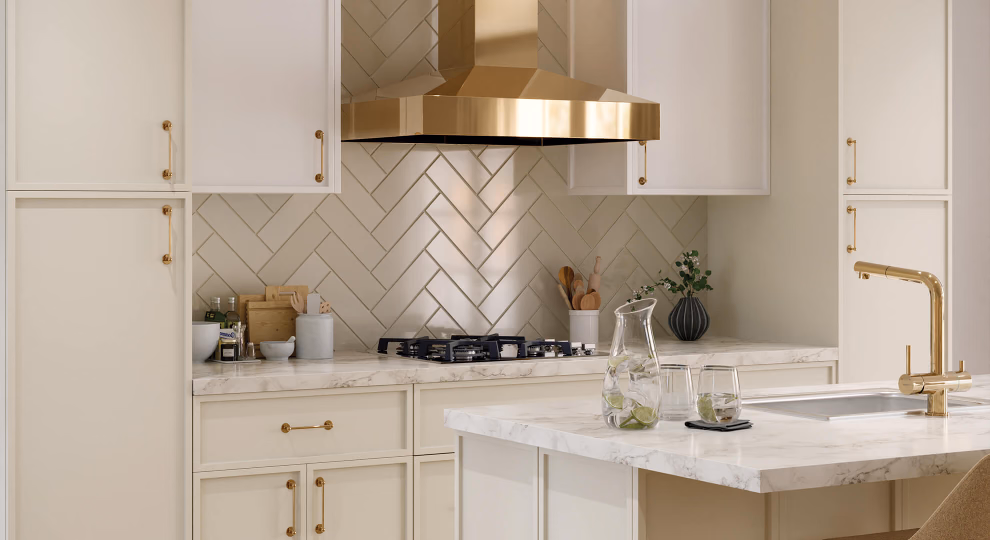 Kitchen: cream slim-shaker (Seaside Dune) with brass hood and herringbone tile